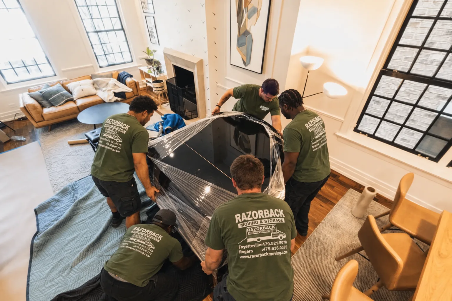 Razorback Moving crew wrapping a grand piano in Rogers Arkansas
