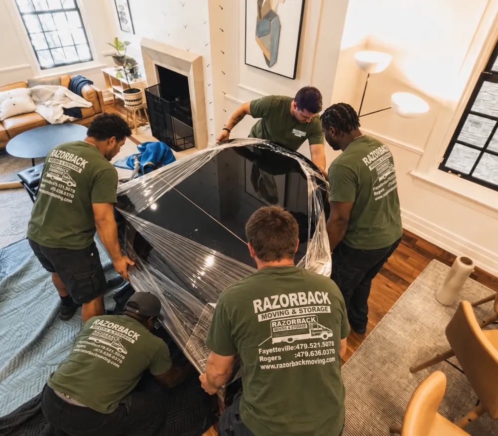 Razorback movers wrapping a grand piano