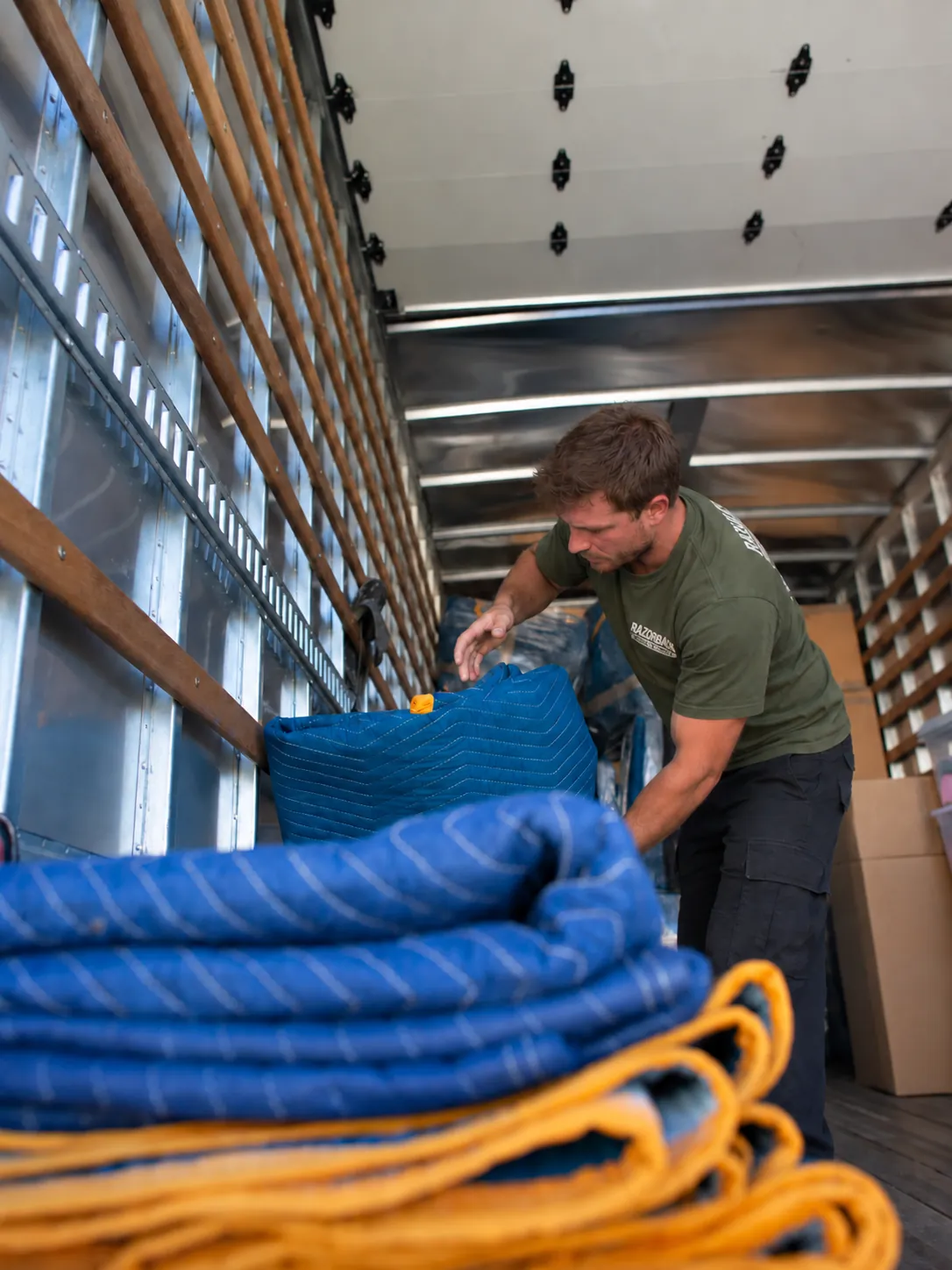Razorback mover arranging protective blankets in a truck