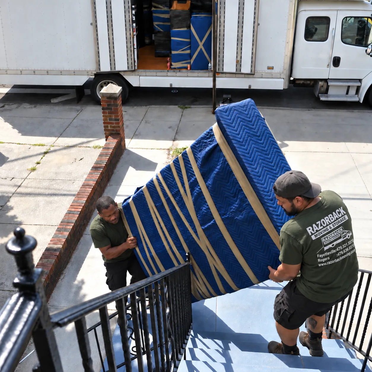 Razorback movers carrying a padded piano