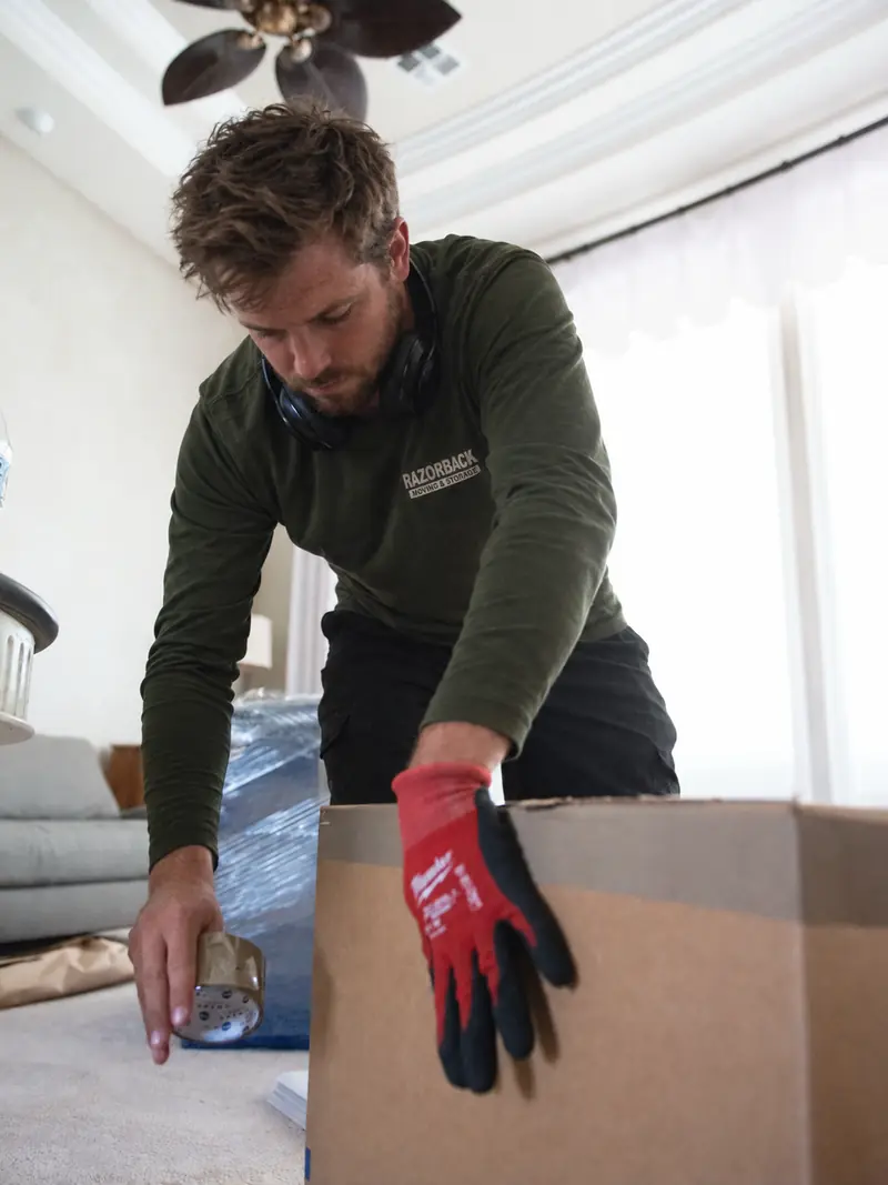 Razorback mover taping a moving box